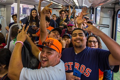 Astros fans celebrate on METRORail as they head to Friday's parade./METRO