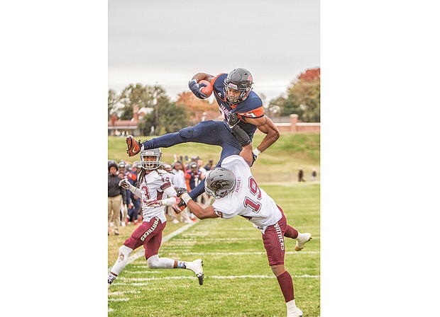 Virginia State University tailback Trenton “Boom” Cannon goes airborne for a touchdown over Virginia University University defensive back Ray Lewis III. His above and beyond effort on the last play of the first half of last Saturday’s game at Rogers Stadium in Ettrick brought the score to 28-17 for VSU. The Trojans won the seesaw of a game with a final score of 40-39 over the Panthers.  