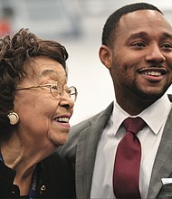 Ryan James, the 29-year-old middle school teacher and winner of the $25,000 Milken Educator Award, is congratulated after Wednesday’s surprise announcement by Lucille M. Brown, former Richmond Public Schools superintendent. The South Side school where Mr. James teaches is named in her honor. 