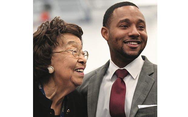 Ryan James, the 29-year-old middle school teacher and winner of the $25,000 Milken Educator Award, is congratulated after Wednesday’s surprise announcement by Lucille M. Brown, former Richmond Public Schools superintendent. The South Side school where Mr. James teaches is named in her honor. 