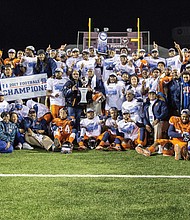 Virginia State University President Makola M. Abdullah and Coach Reggie Barlow hold the CIAA championship trophy as the Trojans celebrate their 42-19 victory last Saturday over Fayetteville State University in Salem. 