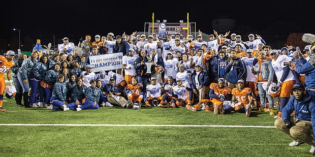 Virginia State University President Makola M. Abdullah and Coach Reggie Barlow hold the CIAA championship trophy as the Trojans celebrate their 42-19 victory last Saturday over Fayetteville State University in Salem. 