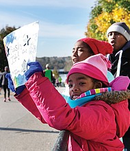 Rooting for Mom//
Glenn Johnson and his daughters, Lena, 9, left, and Zora, 12, cheer the runners in last Saturday’s Richmond Marathon on 5th Street near the Downtown finish line. The family was waiting to spot their wife and mom, Sadeqa, and to give encouragement for the final leg of the course. Please see story on the race, more photos, Page A10.
