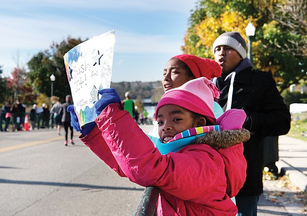 Rooting for Mom//
Glenn Johnson and his daughters, Lena, 9, left, and Zora, 12, cheer the runners in last Saturday’s Richmond Marathon on 5th Street near the Downtown finish line. The family was waiting to spot their wife and mom, Sadeqa, and to give encouragement for the final leg of the course. Please see story on the race, more photos, Page A10.
