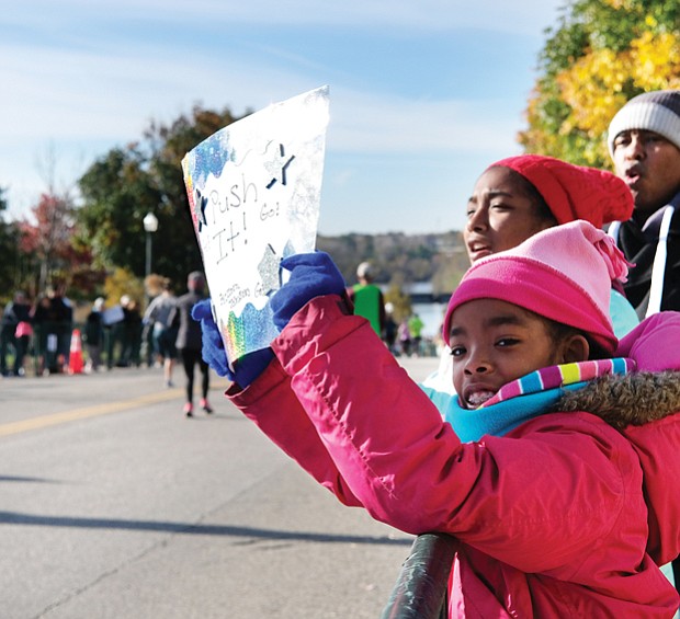 Rooting for Mom//
Glenn Johnson and his daughters, Lena, 9, left, and Zora, 12, cheer the runners in last Saturday’s Richmond Marathon on 5th Street near the Downtown finish line. The family was waiting to spot their wife and mom, Sadeqa, and to give encouragement for the final leg of the course. Please see story on the race, more photos, Page A10.
