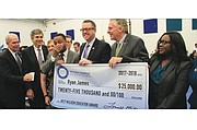 Ryan James wipes away tears of joy has he holds an oversized check presented to him Wednesday by the Milken Family Foundation. With him are, from left, state Superintendent of Public Instruction Steven R. Staples; state Board of Education President Dan Gecker; Laura Marshall, 2008 Milken honoree; Lowell Milken; Wade Whitehead, 2000 Milken honoree; Gov. Terry McAuliffe; and Dr. Stacy G. Gaines, principal of Lucille M. Brown Middle School.
