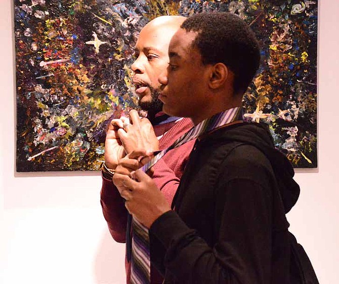 Anthony P. Roberson (pictured right), who is a tie designer for the Satio Foundation for Young Men, recently taught young men how to tie a tie in several knots during a workshop at Ariel Joseph Art Gallery, located on 6323 S. Cottage Grove Ave. Photo Credit: Christopher Shuttlesworth