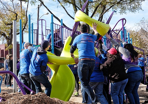 Cityscape // Volunteers work in unison, left, to install new playground equipment at Abner Clay Park, off Leigh Street and Brook Road in Jackson Ward. Right, Jordan Tillman was among the willing workers who participated in the effort to create a better place for children to play. City Councilwoman Kim B. Gray of the 2nd District credited an anonymous donor’s $200,000 gift with making it possible to replace old equipment. KaBoom!, a national nonprofit, joined with Communities in Schools of Richmond, the Historic Jackson Ward Association, 