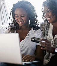 Black mother and daughter shopping online with credit card