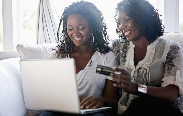 Black mother and daughter shopping online with credit card