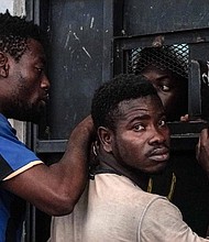 TOPSHOT - Illegal immigrants are seen at a detention centre in Zawiyah, 45 kilometres west of the Libyan capital Tripoli, on June 17, 2017. The Libyan coastguard has rescued more than 900 African and Asian migrants attempting to reach Europe, a navy spokesman said. / AFP PHOTO / Taha JAWASHI (Photo credit should read TAHA JAWASHI/AFP/Getty Images)