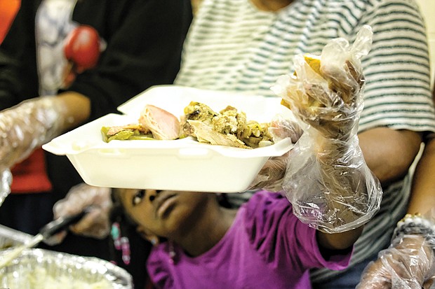 Holiday sharing // People of all ages pitched in to serve others last week at area Thanksgiving celebrations. Top left, Tianna Fields, 5, reaches with a gloved hand to put a roll on a dinner plate for one of the senior residents of the former Essex Village apartment complex in Henrico County. 
