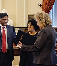 Joseph F. Thekkekara is sworn in as Richmond’s new postmaster Wednesday in the Old House Chamber at the State Capitol. Previously a postmaster in Texas, Illinois and New York communities, he is the 34th person to hold the title in Richmond since the beginning of the postal service around 1778. He is surrounded by family, from left, son Jason, wife Annie and son Justin as the oath of office is administered by Linda Malone, U.S. Postal Service vice president for the Capital Metro area, which stretches from Baltimore to Atlanta. Mr. Thekkekara started his career as a mail carrier in 1988. He succeeds Harold G. O’Connor, who was postmaster for 11 years before being removed in 2016 and retiring earlier this year in the wake of a scandal over management efforts to reduce carrier overtime pay by changing time cards.