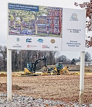 A sign offers the vision of the planned Church Hill North development that now needs a $4.9 million bailout from City Council. Heavy machinery prepares the land in the 1600 block of North 31st Street for the proposed construction of new apartments and homes on the site of the old Armstrong High School.