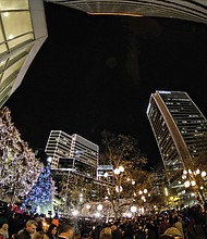 Holiday lights at night // Thousands of people enjoyed the festivities that included music, entertainment and carriage rides in Shockoe Bottom. Several people took refuge from the night air to watch the events from inside the James Center. People also enjoyed festivities at the newly renovated Train Shed at Main Street Station just blocks from the James Center. 