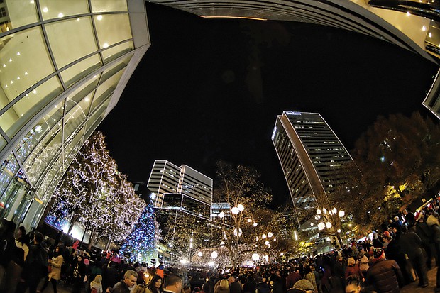 Holiday lights at night // Thousands of people enjoyed the festivities that included music, entertainment and carriage rides in Shockoe Bottom. Several people took refuge from the night air to watch the events from inside the James Center. People also enjoyed festivities at the newly renovated Train Shed at Main Street Station just blocks from the James Center. 