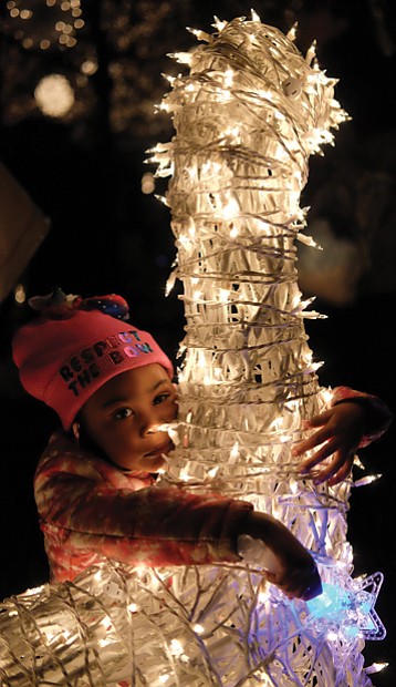 Holiday lights at night // Richmond’s Downtown skyline is bathed in holiday lights as the 33rd Annual Grand Illumination kicked off the season last Friday at the James Center. Children and adults alike were dazzled by the spectacle, including Victoria Austin, 3, who posed with a reindeer as her mother, Samantha, snapped photos. 