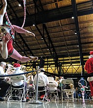 Mina Corbeau, a performer with Host Of Sparrows Aerial Circus, thrills spectators, below, along with Santa and the band at Main Street Station. 