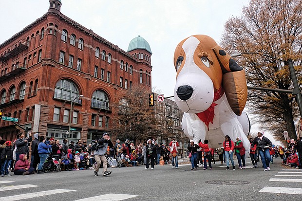 Welcoming Christmas on parade // There’s nothing like a parade to get into the holiday spirit. Thousands of people lined Broad Street from the Science Museum to 7th Street in Downtown for the 34th Annual Dominion Energy Christmas Parade last Saturday. Floats included big inflatables, such as this giant puppy balloon, right, that was guided down the street by a bevy of volunteers. The day wasn’t just for the young. Middle left, adults and seniors cheered and dance on the sidelines as marching bands and cheerleading units pass by. Middle right, grand marshals of this year’s parade, retired NASA mathematician and aeronautical engineer Christine Darden, 
 