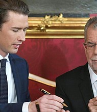 Austrian President Alexander Van der Bellen (R) and Austrian Chancellor of the conservative People's Party (OeVP) Sebastian Kurz sign the letter of appointment during the inauguration ceremony.