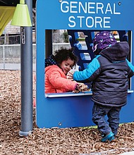 Amanda Gamble, 2, pretends to sell leaves to her year-old brother, 