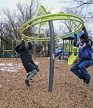 Monica and Barry Gamble, try out a ring swing on the new “Tot Lot” last Friday at the city’s newest playground for children. Location: 2001 3rd Ave. in North Side’s Highland Park. The city Department of Parks, Recreation and Community Facilities developed the playground. 