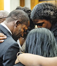 Family members embrace new Richmond Mayor Levar M. Stoney in a prayer circle before he takes the oath of office at Richmond City Hall on Dec. 31, 2016. Below, throngs of demonstrators, many wearing signature pink hats, crowd Washington streets the day after President Trump’s inauguration in January for the Women’s March on Washington.
