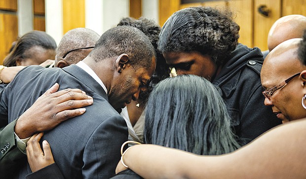 Family members embrace new Richmond Mayor Levar M. Stoney in a prayer circle before he takes the oath of office at Richmond City Hall on Dec. 31, 2016. Below, throngs of demonstrators, many wearing signature pink hats, crowd Washington streets the day after President Trump’s inauguration in January for the Women’s March on Washington.
