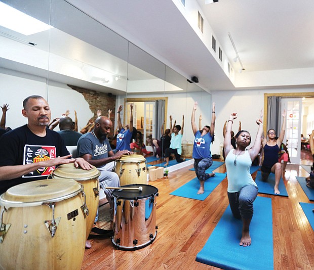 Ram Bhagat, left, and his drum circle set the beat for a yoga session in June at a Jackson Ward juice and yoga bar.