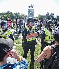 Richmond Police officers in riot gear separate neo-Confederates and counterprotesters during a rally Sept. 16 at the Robert E. Lee monument in Richmond.