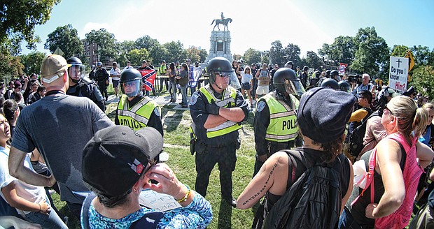 Richmond Police officers in riot gear separate neo-Confederates and counterprotesters during a rally Sept. 16 at the Robert E. Lee monument in Richmond.