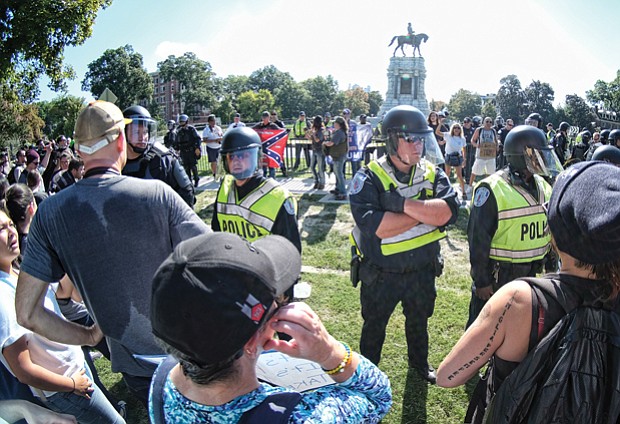 Richmond Police officers in riot gear separate neo-Confederates and counterprotesters during a rally Sept. 16 at the Robert E. Lee monument in Richmond.