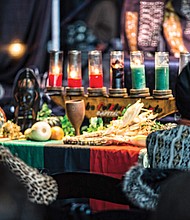 Celebrating Kwanzaa // The community celebrated Kwanzaa at last Saturday’s 27th Annual Capital City Kwanzaa Festival held at the Dewey Gottwald Center on the campus of the Science Museum of Virginia. Crystal Turner, right, participates in lighting the candles, each of which represents one of the seven principles celebrated by the holiday. The black candle in the middle represents Umoja, or unity, while the red candles represent Kujichagulia (self-determination), Ujamaa (cooperative economics) and Kuumba (creativity) and the green candles represent Ujima (collective work and responsibility), Nia (purpose) and Imani (faith). 
