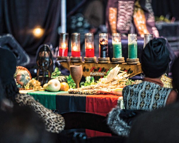 Celebrating Kwanzaa // The community celebrated Kwanzaa at last Saturday’s 27th Annual Capital City Kwanzaa Festival held at the Dewey Gottwald Center on the campus of the Science Museum of Virginia. Crystal Turner, right, participates in lighting the candles, each of which represents one of the seven principles celebrated by the holiday. The black candle in the middle represents Umoja, or unity, while the red candles represent Kujichagulia (self-determination), Ujamaa (cooperative economics) and Kuumba (creativity) and the green candles represent Ujima (collective work and responsibility), Nia (purpose) and Imani (faith). 
