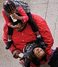 Ringing in the new year! // Darius Robinson Sr. had his hands full at the museum party, with his daughter, Mariah, 3, on his shoulders and year-old son, Darius Jr., out like a light on his arm. 
