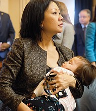 Fairfax Delegate Kathy Tran takes in the action on her first day as a legislator while her less than impressed baby, Elsie, naps.  