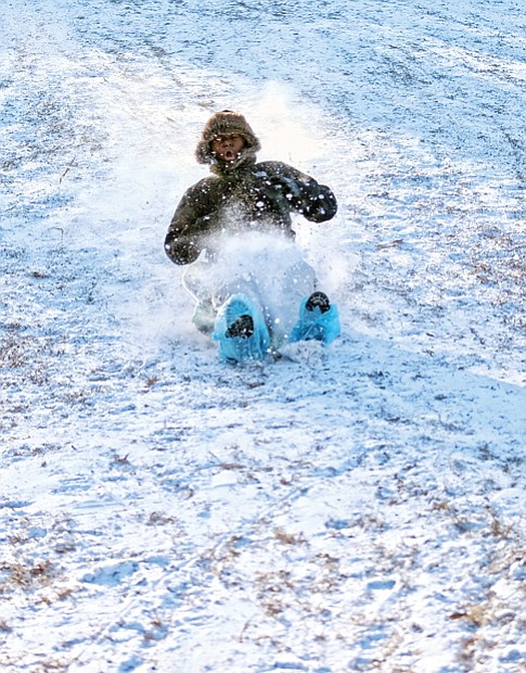 Slippery slope  //
Jamon Lewis, 11, makes the snow fly as he slides down a steep slope at Forest Hill Park in South Side last Friday. The snow created fun, but also icy conditions that led school systems in the Richmond area to close through Tuesday. Classes resumed Wednesday. The cold and ice also caused power outages and froze water pipes in untold numbers of homes and businesses. Underground water infrastructure also cracked, shutting off the water supply in Church Hill, parts of Downtown and in nearby suburbs. On Monday and Tuesday, cracked water mains twice caused partial closure of Interstate 95 in Richmond as water flooded the highway.