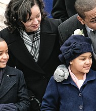 Lt. Gov. Justin e. Fairfax and his wife, Dr. Cerina Fairfax, enjoy the performers and units in the inaugural parade from the stands with their children, Cameron, left, and Carys.