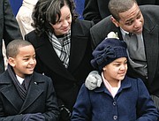 Lt. Gov. Justin e. Fairfax and his wife, Dr. Cerina Fairfax, enjoy the performers and units in the inaugural parade from the stands with their children, Cameron, left, and Carys.
