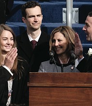 Gov. Ralph s. Northam is sworn into office last saturday by family friend, retired Accomack County Circuit Court Judge Glen A. Tyler, amid the smiles of his wife, Pam, holding the bible, and their children, Aubrey and Wes.