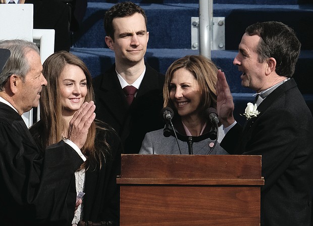 Gov. Ralph s. Northam is sworn into office last saturday by family friend, retired Accomack County Circuit Court Judge Glen A. Tyler, amid the smiles of his wife, Pam, holding the bible, and their children, Aubrey and Wes.