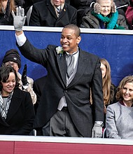 Lt. Gov. Justin E. Fairfax, only the second African-American to be elected to statewide office in Virginia, waves to a cheering crowd after taking the oath of office. His wife, Dr. Cerina Fairfax, a dentist, seated at left, held the Bible while their two children watched. Seated with him on the platform are, from left, Attorney General Mark R. Herring, Pam Northam and her husband, Gov. Ralph S. Northam.
