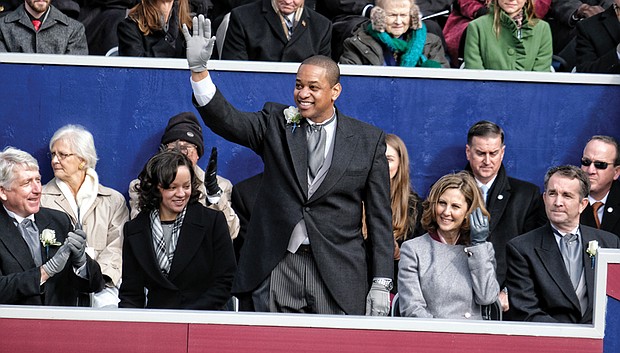 Lt. Gov. Justin E. Fairfax, only the second African-American to be elected to statewide office in Virginia, waves to a cheering crowd after taking the oath of office. His wife, Dr. Cerina Fairfax, a dentist, seated at left, held the Bible while their two children watched. Seated with him on the platform are, from left, Attorney General Mark R. Herring, Pam Northam and her husband, Gov. Ralph S. Northam.
