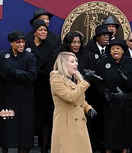 Larry Bland and the Volunteer Choir accompany the mother-daughter country group, Marna & Macy, in the final song at the inaugural ceremony. They are, from right, Marna Bales; her daughter, Macy Kaczmarek, center; and Ms. Bales’ husband, Jody Boyd, on acoustic guitar. 