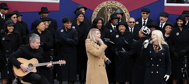 Larry Bland and the Volunteer Choir accompany the mother-daughter country group, Marna & Macy, in the final song at the inaugural ceremony. They are, from right, Marna Bales; her daughter, Macy Kaczmarek, center; and Ms. Bales’ husband, Jody Boyd, on acoustic guitar. 