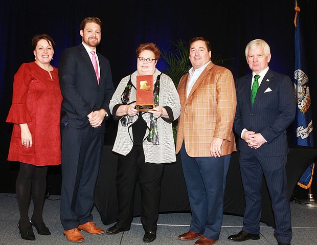 Shelley Johnson, executive director/CEO of the Lake Charles/Southwest Louisiana Convention & Visitors Bureau (center) receives the Will Mangham Tourism Lifetime Achievement Award as presented by (left to right) Jill Kidder, president/CEO of the Louisiana Travel Association (LTA); Travis Napper, president/CEO of the Ruston Lincoln CVB and LTA chairman; Lt. Gov. Billy Nungesser; and Mark Romig, New Orleans Tourism Marketing Corporation president/CEO and past LTA chairman.