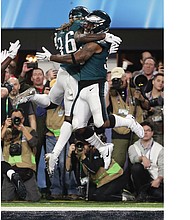 the Philadelphia Eagles’ Corey Clement, right, celebrates his touchdown with running back Jay Ajayi during Sunday’s Super Bowl game