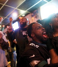 Philadelphia Eagles fans Devon Bailey, left, and Emma Dickson cheer on their team Sunday at Reales Bar in Philadelphia.