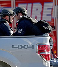 Police officers tend to a victim as they ride in the back of a pickup truck. John McCall/Sun Sentinel/TNS/Getty Images