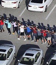 Students form a chain as they are brought out of the school. Joe Raedle/Getty Images